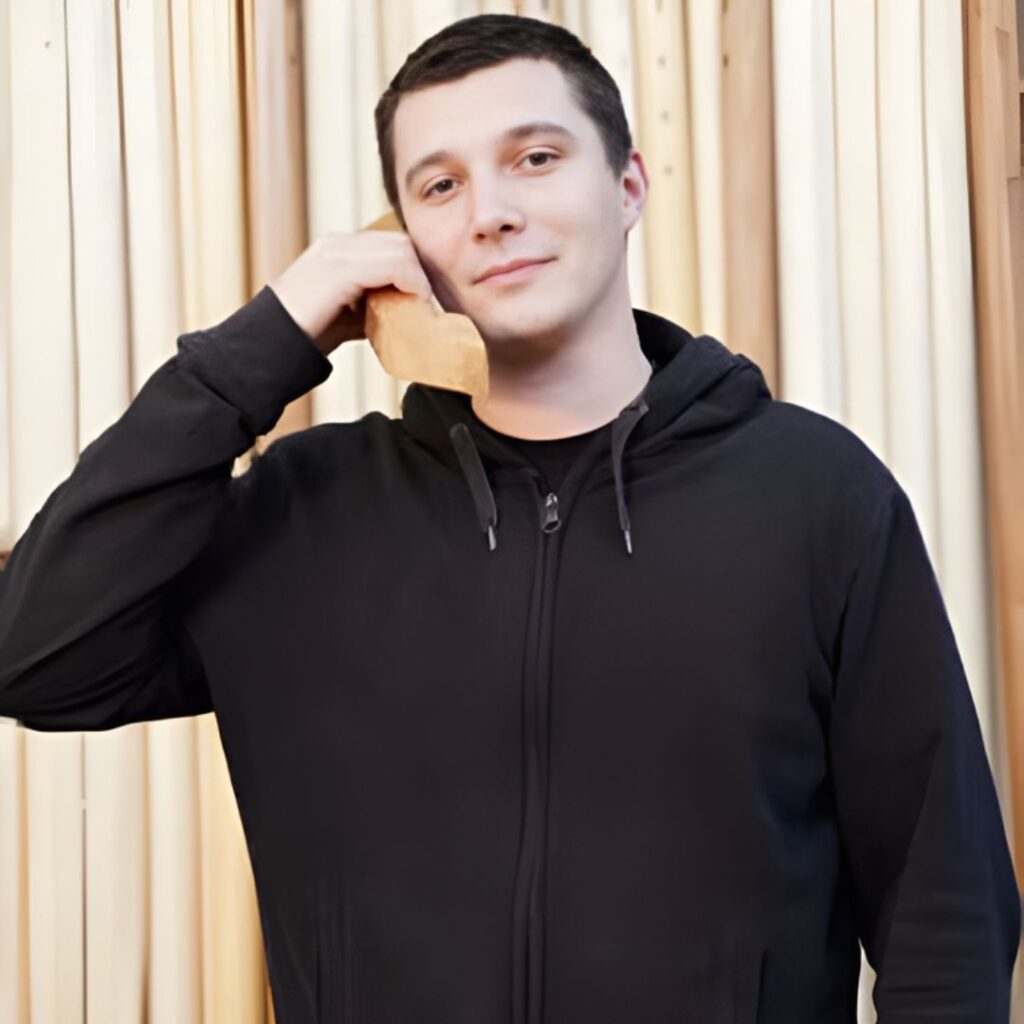 Persona che tiene in mano un telefono di legno