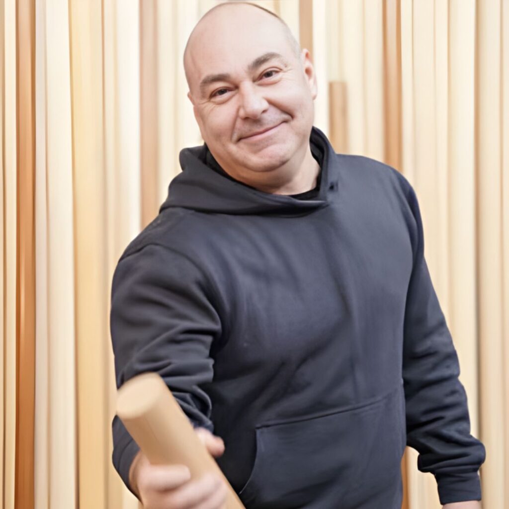 Persona che porge un pezzo di legno cilindrico